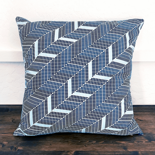 navy teal and white geometric diagonal herringbone pillow on bench