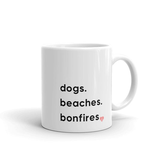 Ceramic mug with dogs, beaches, bonfires text and anchor inside a pink heart-front view